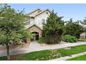 Beautiful home featuring a stone archway entrance surrounded by lush landscaping at 10010 E Gunnison Pl # 707, Aurora, CO 80247