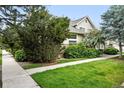 Well-maintained side yard with lush greenery and a sidewalk leading to the home's entrance at 10010 E Gunnison Pl # 707, Aurora, CO 80247