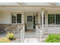 Inviting front porch featuring decorative wreath and stone accents around the entryway at 10877 W 55Th Ln, Arvada, CO 80002