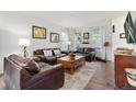 Comfortable living room with hardwood floors, featuring leather sofas, and a decorative rug at 14791 E Poundstone Dr, Aurora, CO 80015