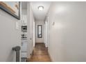 Clean hallway featuring hardwood floors, a mirror, and access to the kitchen at 2281 S Vaughn Way # 316A, Aurora, CO 80014