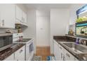 This kitchen has a sink, microwave, range, laminate flooring, and ample counter space at 2281 S Vaughn Way # 316A, Aurora, CO 80014