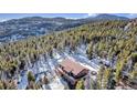 A cabin with an outdoor spa surrounded by snow-covered pine trees, perfect for relaxation at 255 Divide View Dr, Golden, CO 80403