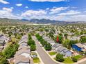 A charming neighborhood with lush trees and mountain views in the distance at 9595 Elk Mountain Cir, Littleton, CO 80125
