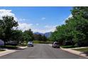 A quiet residential street with well-maintained homes and mature trees in the distance at 9595 Elk Mountain Cir, Littleton, CO 80125