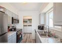 Contemporary kitchen with stainless steel appliances, stylish cabinets, and laminate flooring at 2080 E 84Th Ave, Denver, CO 80229