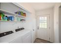 Convenient laundry area with modern appliances and shelving for storage at 2080 E 84Th Ave, Denver, CO 80229