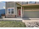 Home's welcoming front porch area, featuring bench seating, a red door, and a well-kept front yard at 9615 Lansing Cir, Commerce City, CO 80022