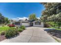 A bright ranch-style home with an attached garage and ample parking on a sunny day at 5071 S Boston St, Greenwood Village, CO 80111
