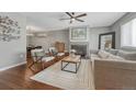 Comfortable living room with a stone fireplace, plush sofa, and two chairs on top of hardwood flooring at 5071 S Boston St, Greenwood Village, CO 80111