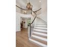 Grand foyer with beautiful staircase and chandelier is a welcome entrance at 5331 S Geneva Way, Englewood, CO 80111