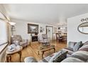 Spacious living room with hardwood floors, fireplace, and large windows at 4909 W Mississippi Ave, Denver, CO 80219