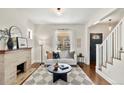 Inviting living room with fireplace, contemporary furnishings, and access to the staircase at 4130 Umatilla St, Denver, CO 80211