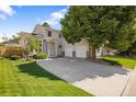 Beautiful home with an attached two-car garage, a well-manicured lawn, and shade trees at 15157 E Nassau Ave, Aurora, CO 80014