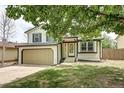 Inviting two-story home with an attached garage and a vibrant green lawn at 1488 S Biscay Ct, Aurora, CO 80017