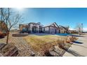 Attractive home with a manicured front yard, well-kept lawn, rock features, and a spacious three-car garage at 1724 Silverado Ln, Fort Lupton, CO 80621