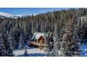 Aerial view of a stunning log home with a large deck, winter scene at 229 Lee Ln, Breckenridge, CO 80424