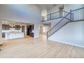 Open-concept living space with light wood floors, staircase with metal railings, and abundant natural light at 8724 Big Thompson St, Littleton, CO 80125