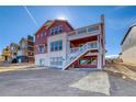This two-story home features a backyard, a second-story balcony with stairs to the lower level, and a white brick foundation at 8724 Big Thompson St, Littleton, CO 80125