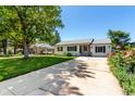 Charming single-story home with a well-manicured lawn, long driveway, and inviting curb appeal at 1748 W Tennessee Ave, Denver, CO 80223