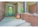 Inviting front porch with brick accents, a green door, and a potted plant at 467 S Reed Ct, Lakewood, CO 80226