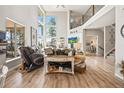 Open-concept living room showcasing wood floors, tall windows and stairs to the second floor at 16231 Thunder Cat Way, Monument, CO 80132