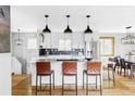 Modern kitchen with white cabinets, stainless steel appliances, granite countertops, and stylish pendant lighting at 1908 Taft Dr, Lakewood, CO 80215