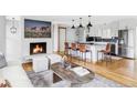 Bright, open concept living room with a fireplace, breakfast bar, and wood flooring at 1908 Taft Dr, Lakewood, CO 80215