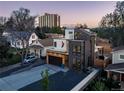 Modern home exterior featuring mixed materials, a balcony, and spacious driveway, with neighborhood view at 1655 Wolff St, Denver, CO 80204