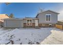 Charming two-story home with gray siding, brick foundation, and a snowy front yard at 16046 E Harvard Ave, Aurora, CO 80013