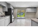 Bright kitchen with modern appliances, light gray cabinets, granite countertops, and a sliding glass door to the backyard at 8305 Eaton Way, Arvada, CO 80003