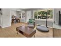 Bright living room with hardwood floors, chair with ottoman, large windows, and modern furniture at 1225 S Honey Way, Denver, CO 80224