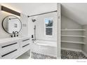 Modern bathroom featuring sleek fixtures, a shower-tub combo, and decorative tiling at 5138 W 46Th Ave, Denver, CO 80212