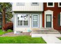 Close-up of a well-maintained two-story townhome with a lovely front yard and charming entrance at 9946 W Cornell Pl, Lakewood, CO 80227