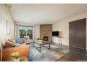 Comfortable living room with a stone fireplace and sliding glass doors to the outside at 430 Zang St # 4-102, Lakewood, CO 80228