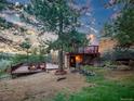The outside of this house has a deck with a table and chairs for enjoying outdoor time at 8791 Grizzly Way, Evergreen, CO 80439