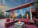 Exterior of a home with expansive deck, fire pit, outdoor seating, and beautiful mountain views at 8791 Grizzly Way, Evergreen, CO 80439
