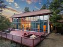 The wall of windows lets in tons of light, also features a large deck with chairs and a fire pit at 8791 Grizzly Way, Evergreen, CO 80439