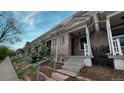 Exterior view of this charming townhome with tidy landscaping with attractive stairway entrance at 553 N Logan St, Denver, CO 80203