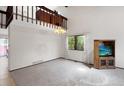 Spacious living area with neutral carpet, large window, and modern lighting at 8133 W Quarto Ave, Littleton, CO 80128