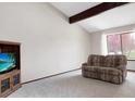 Bright living room with vaulted ceilings, beam accents, and plush carpet at 8133 W Quarto Ave, Littleton, CO 80128