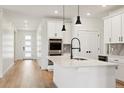 A kitchen with white cabinets, stainless steel appliances, a kitchen island, and hardwood floors at 42966 Colonial Trl, Elizabeth, CO 80107