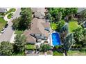 A beautiful aerial view of a home's roof, in-ground swimming pool and lush landscaping at 5955 Blue Sage Way, Littleton, CO 80123