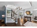 Bright foyer with a curved staircase, hardwood floors, and an elegant round mirror at 5955 Blue Sage Way, Littleton, CO 80123
