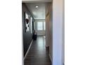 Hallway with dark accent wall, modern lighting and contrasting baseboards at 1109 Sunrise Dr, Lochbuie, CO 80603