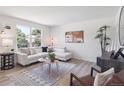 Bright living room featuring hardwood floors, a modern sofa, and neutral decor at 1718 S Flanders Way, Aurora, CO 80017