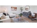 Stylish living room featuring hardwood floors, a modern sofa, and neutral decor at 1718 S Flanders Way, Aurora, CO 80017
