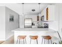 Bright kitchen features white cabinets, stainless steel appliances, and breakfast bar seating at 909 N Logan St # 3A, Denver, CO 80203