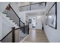 Bright foyer with hardwood floors and an open staircase at 6977 Copper Sky Cir, Castle Pines, CO 80108
