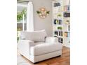 Bright living room featuring a plush armchair, a floral decoration, and built-in bookshelves at 577 Tristan Pl, Berthoud, CO 80513